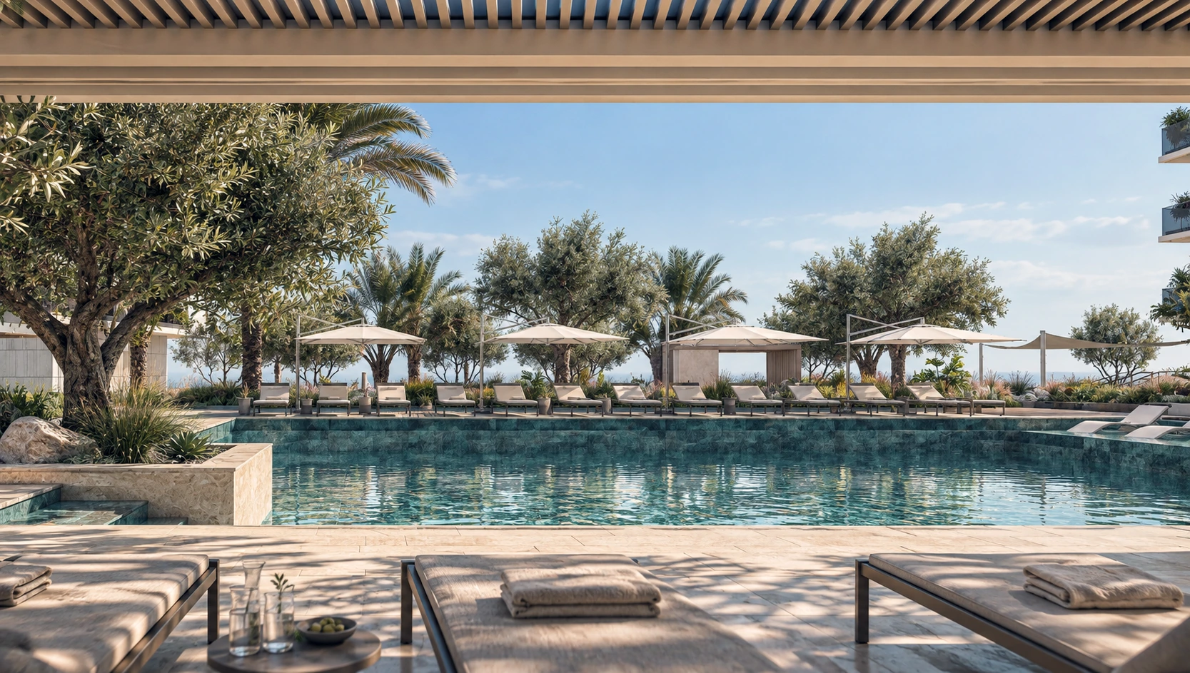 Swimming pool surrounded by loungers, shaded cabanas and landscaped gardens.